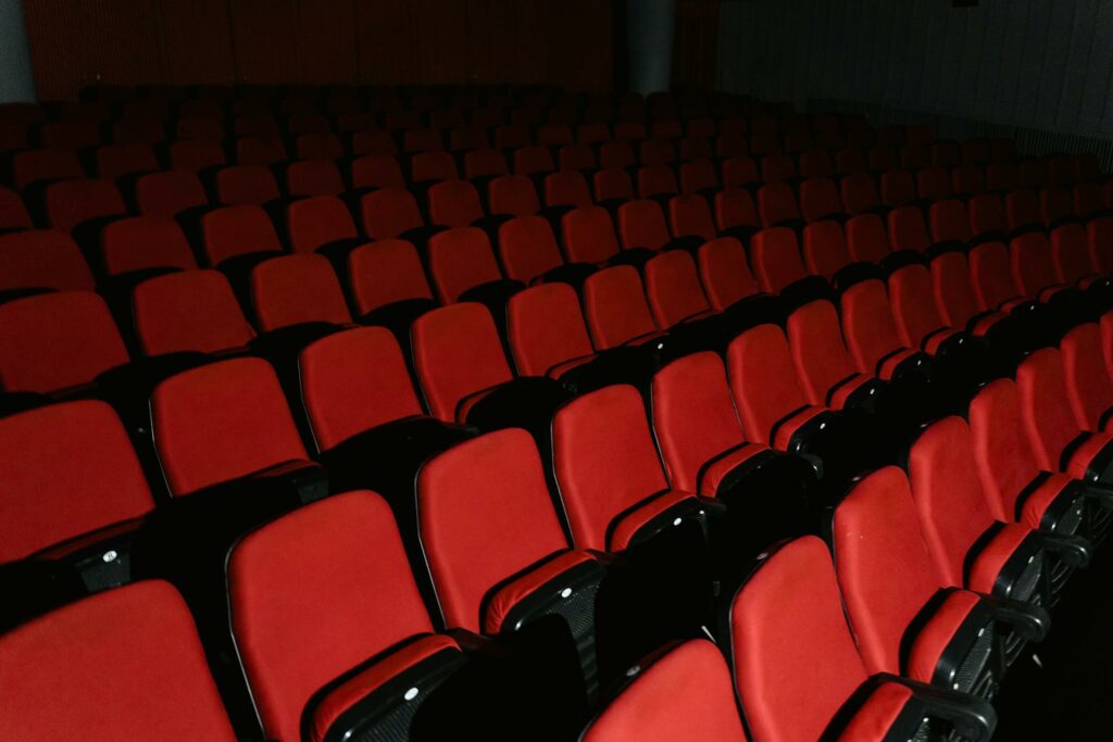 Sièges rouges repliés dans une salle de théâtre vide
